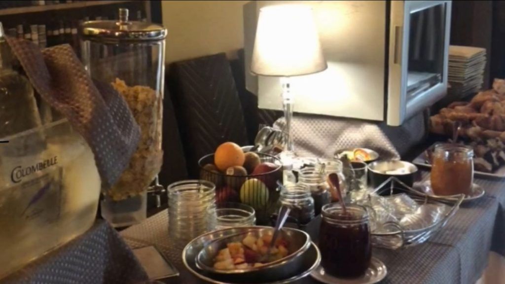 Salade de fruits et pot de confiture sur une table.