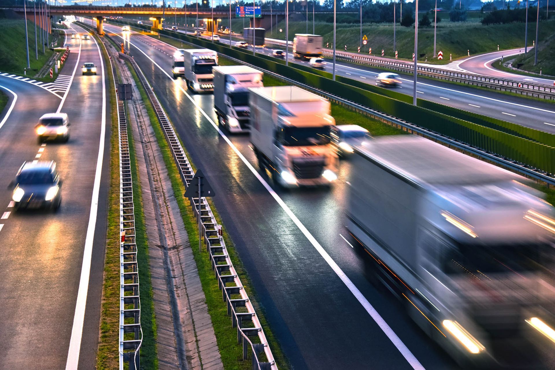 Viele Lastwagen fahren nachts auf einer Autobahn.