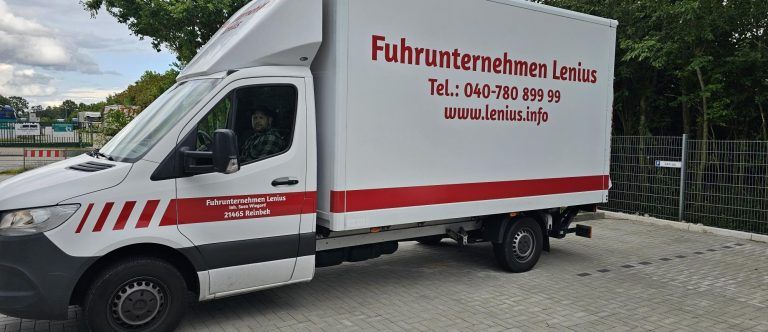 Ein weiß - roter Lieferwagen steht auf einem Parkplatz.