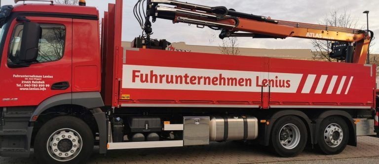 Ein roter LKW mit den Worten Fuhrunternehmen Lenius auf der Seite