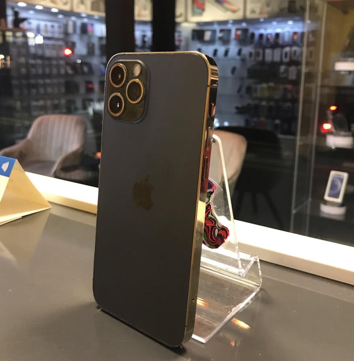 Eine Person mit schwarzen Handschuhen zerlegt einen Laptop auf einem Schreibtisch, umgeben von Werkzeugen und Bauteilen.