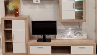 Una sala de estar con un televisor de pantalla plana en un centro de entretenimiento de madera.