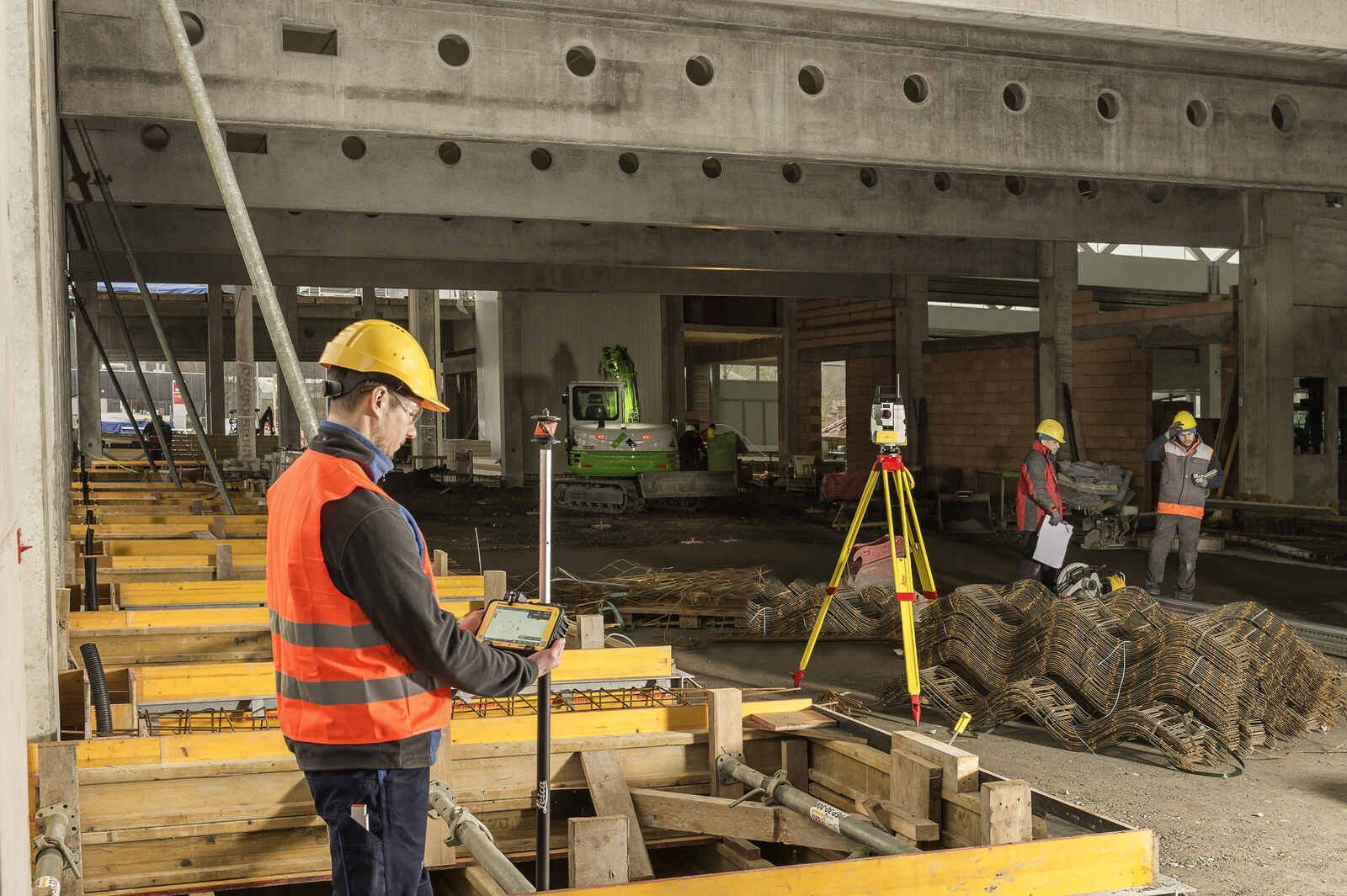 Ein Bauarbeiter benutzt auf einer Baustelle ein Tablet.