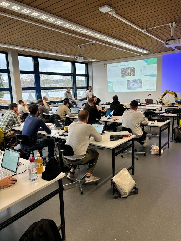 Eine Gruppe von Menschen sitzt an Tischen in einem Klassenzimmer.