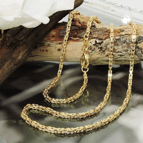 Eine Goldkette liegt auf einem Stück Holz