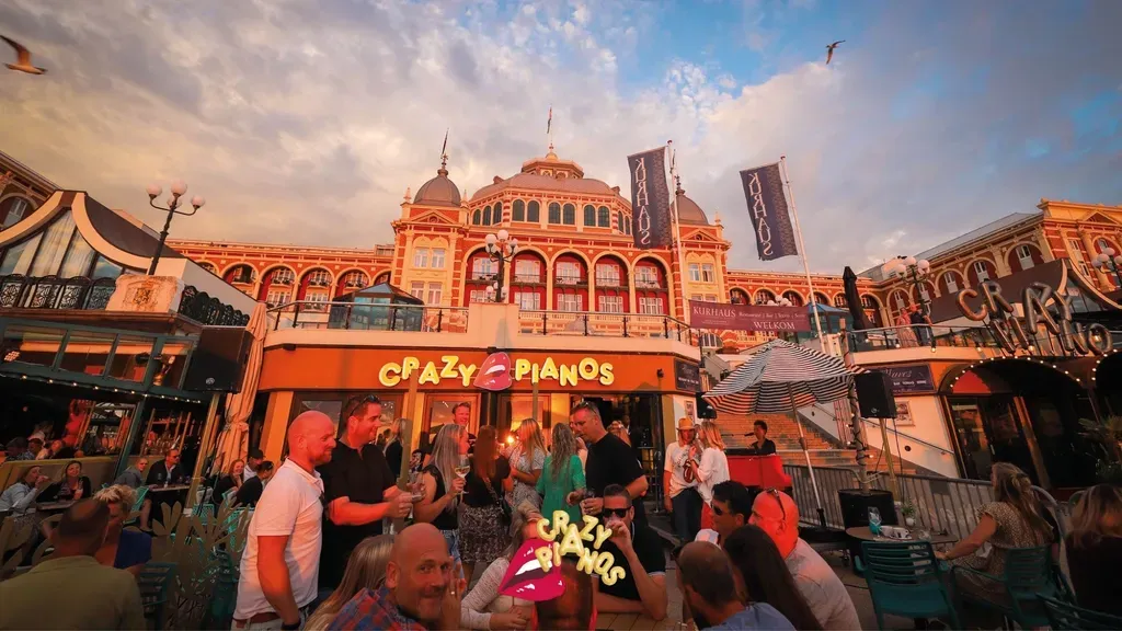 A group of people are standing outside of a restaurant called crazy pianos.