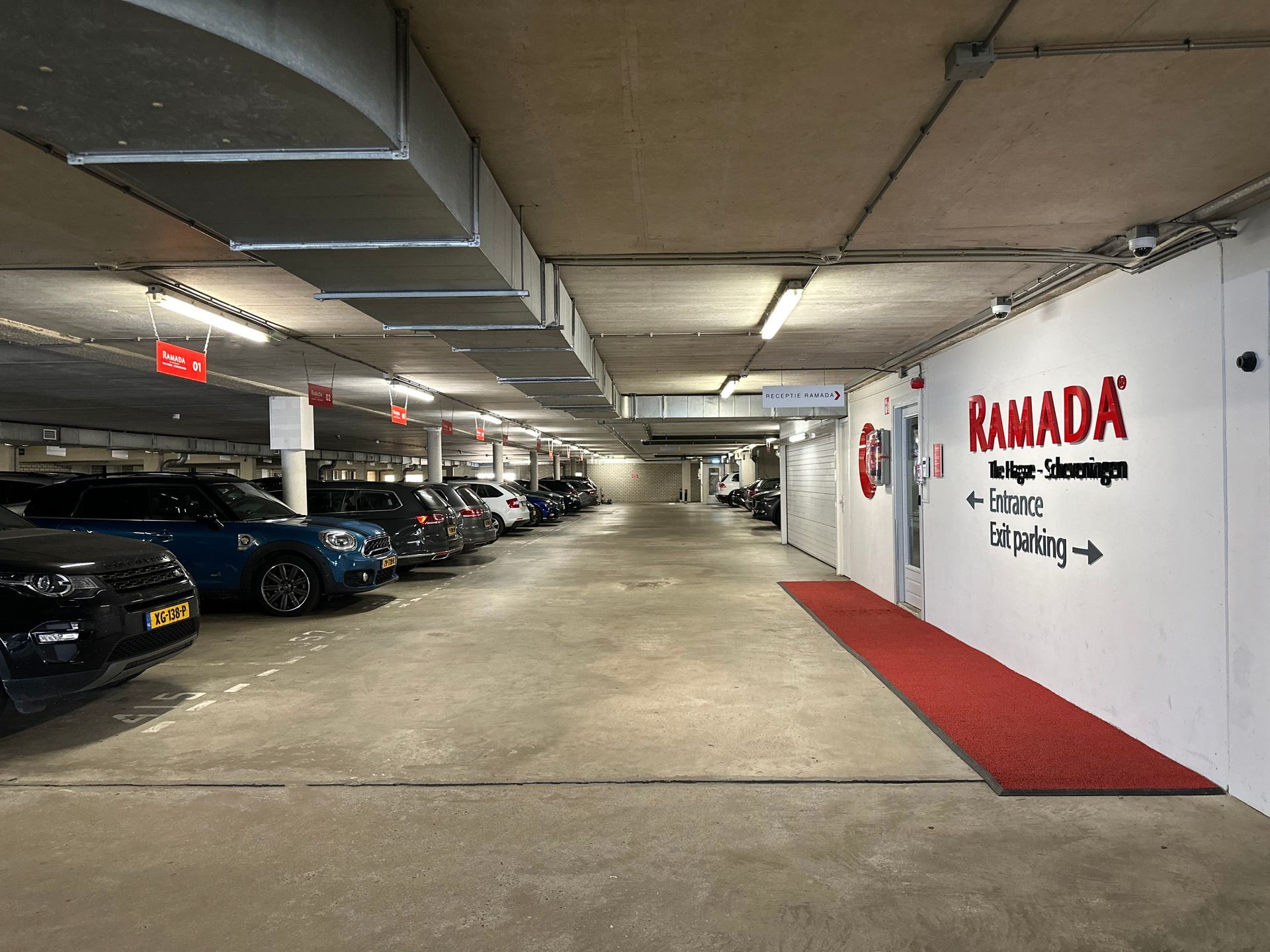 Een parkeergarage met geparkeerde auto's en een rode loper.