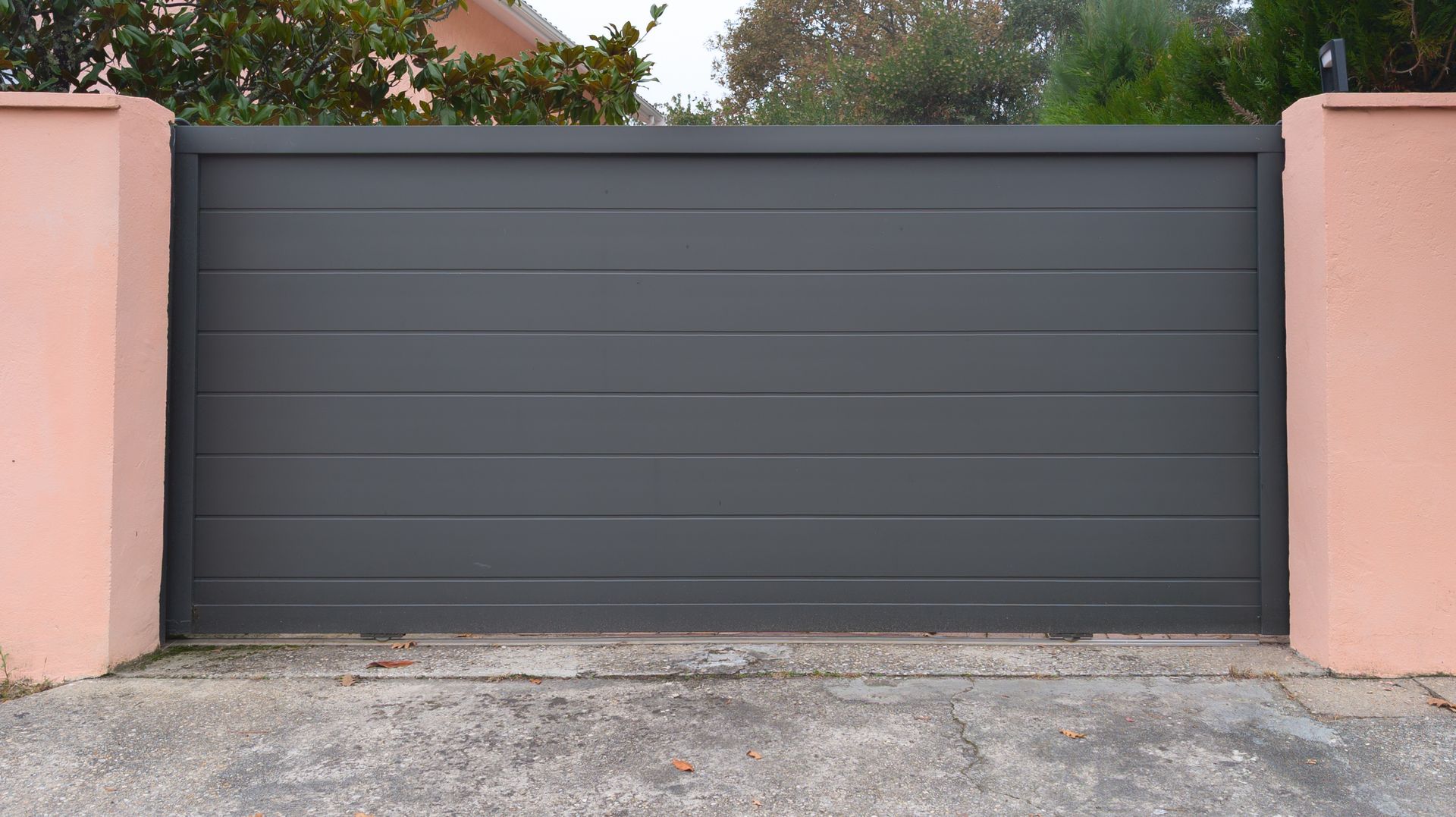 Portail coulissant noir à bandes.