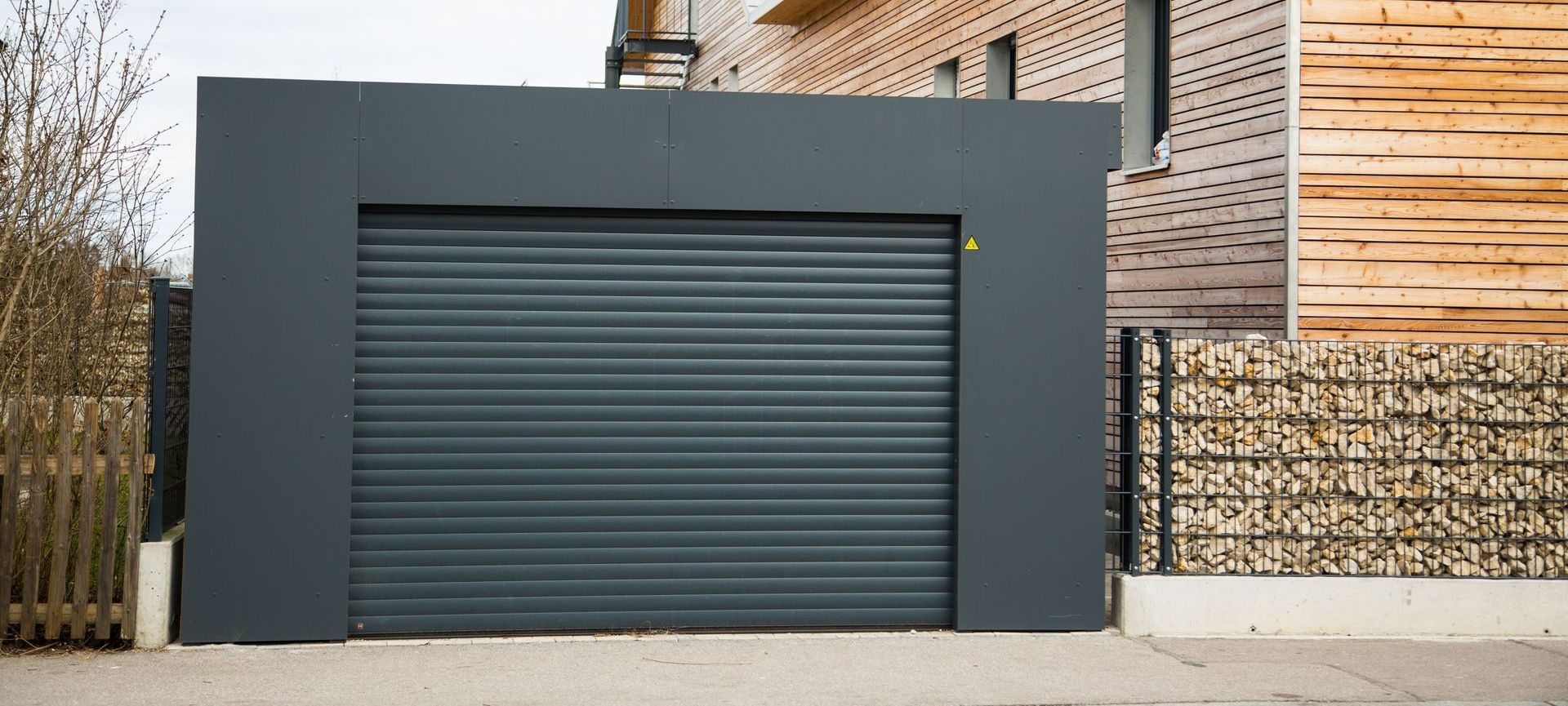 Porte de garage noire roulante.
