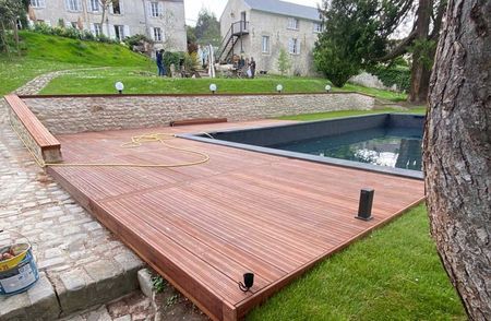 Terrasse en bois et muret autour d’une piscine