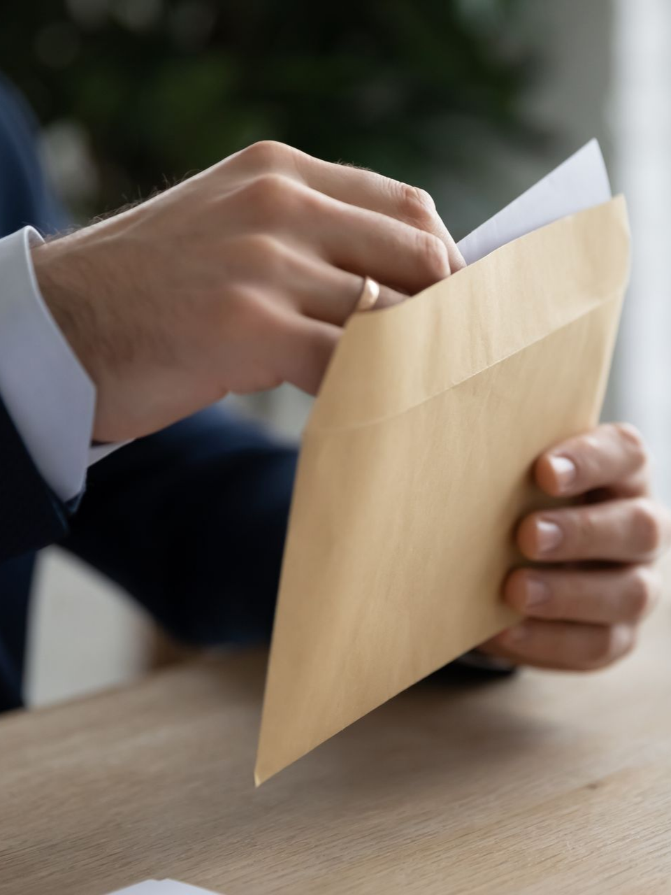 Un homme en costume ouvrant une enveloppe