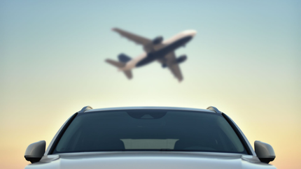 Une voiture avec un avion au-dessus d'elle dans les airs