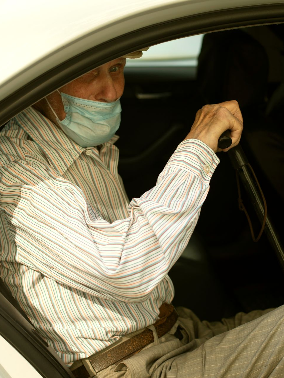 Un homme âgé sortant d'une voiture avec sa canne