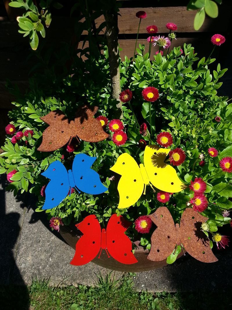 Ein Blumentopf gefüllt mit Blumen und Schmetterlingen in verschiedenen Farben