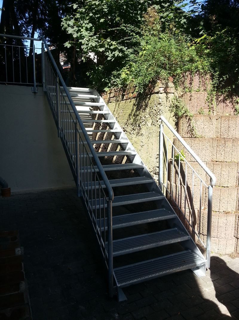 Eine Metalltreppe mit Metallgeländer, die einen Hügel hinaufführt.