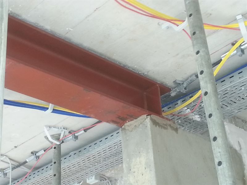 Eine Decke mit einem Metallträger und daran hängenden Drähten