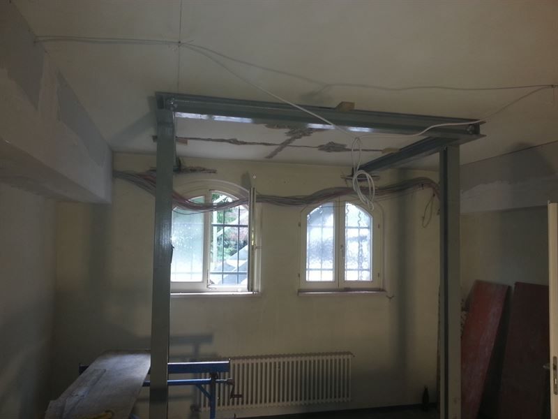 Ein leerer Raum mit einem Fenster und einem Heizkörper.