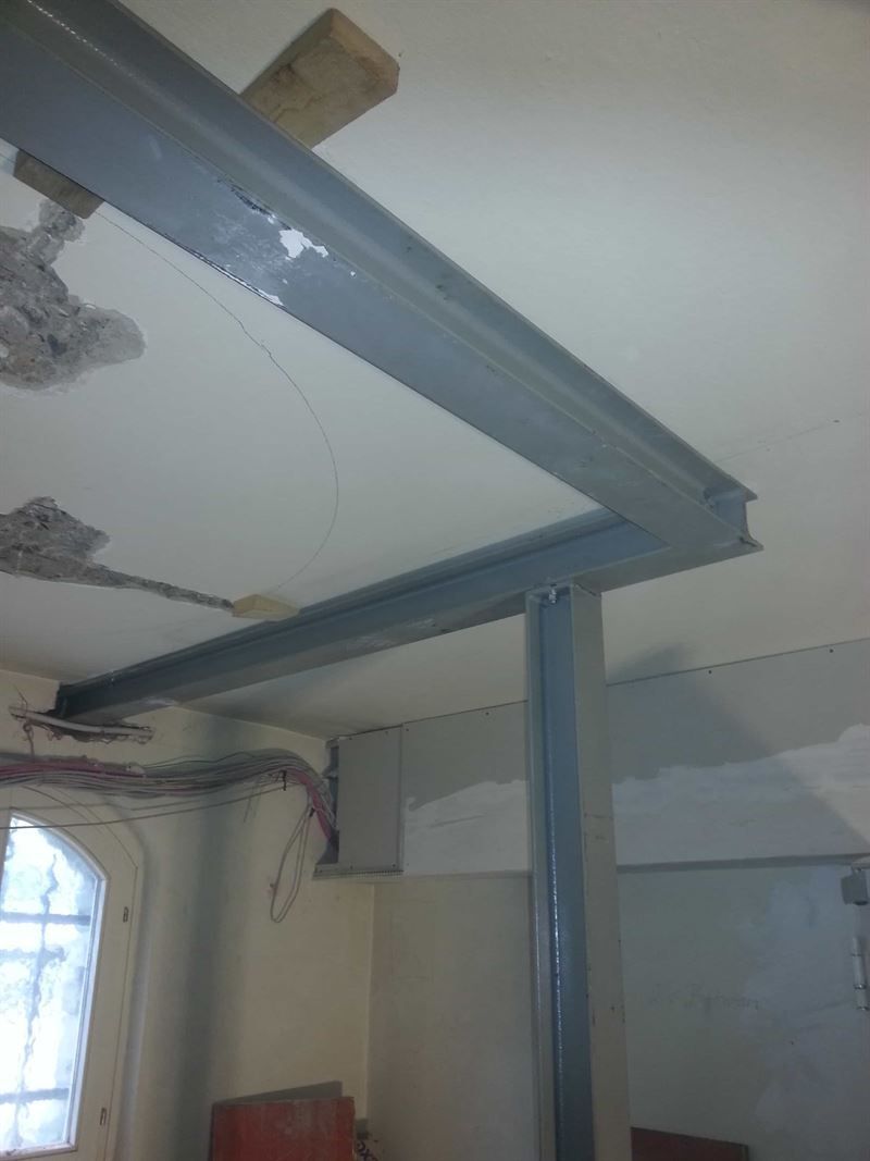 Ein Raum mit einer Decke, an der sich ein Metallträger befindet