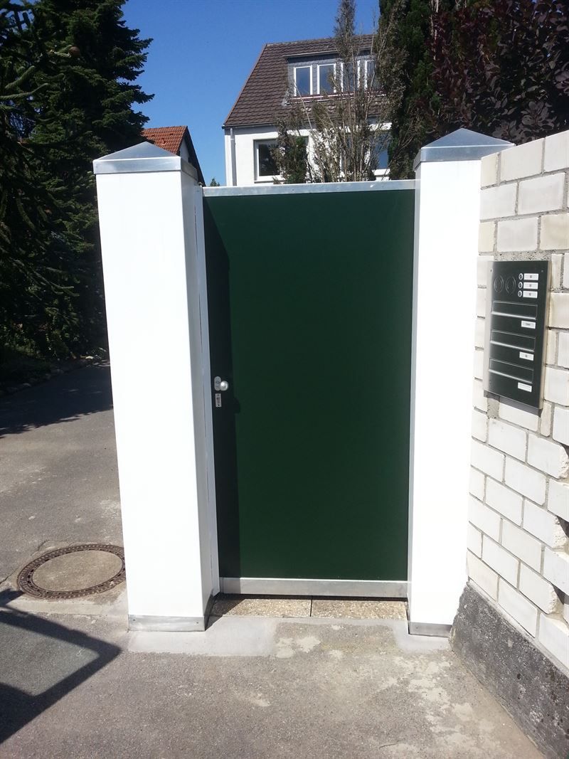 Eine grüne Tür befindet sich zwischen zwei weißen Säulen