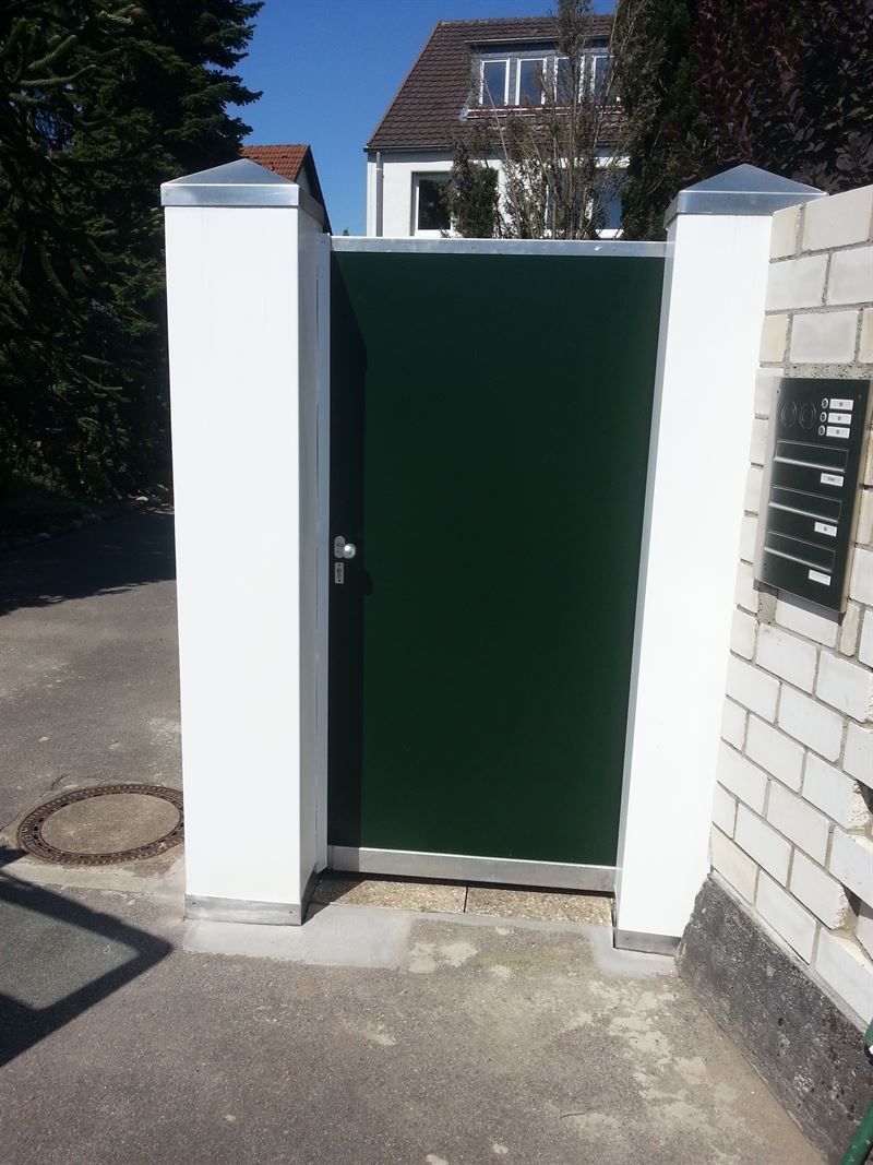 Eine grüne Tür ist hinter einer weißen Backsteinmauer