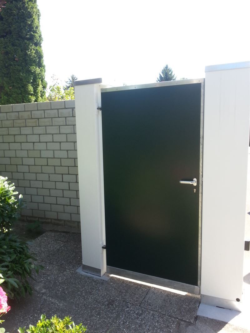 Eine schwarze Tür mit einer weißen Ziegelwand dahinter