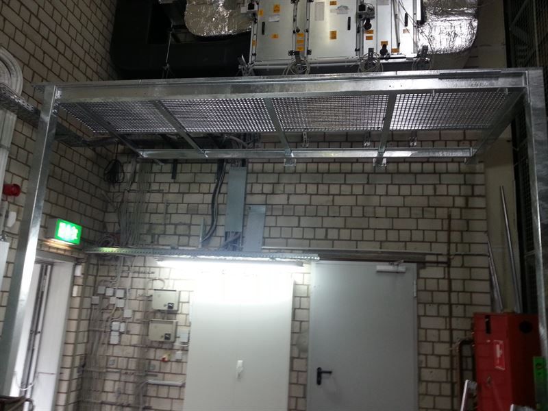 Ein Raum mit einer Ziegelwand und einem Metallregal darüber.