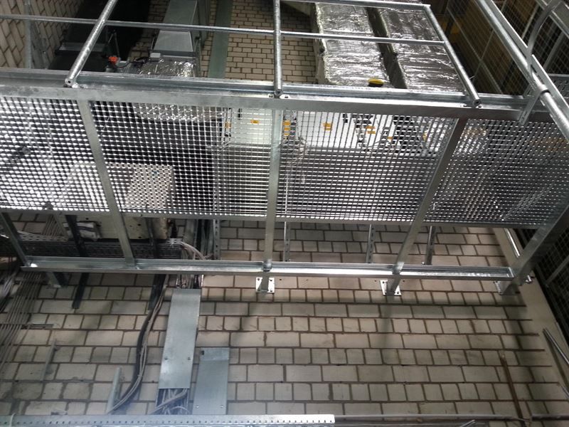 Auf einer Backsteinmauer steht ein Metallkäfig.