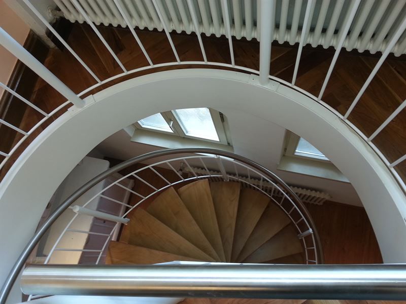 Blick nach unten auf eine Wendeltreppe mit weißem Geländer
