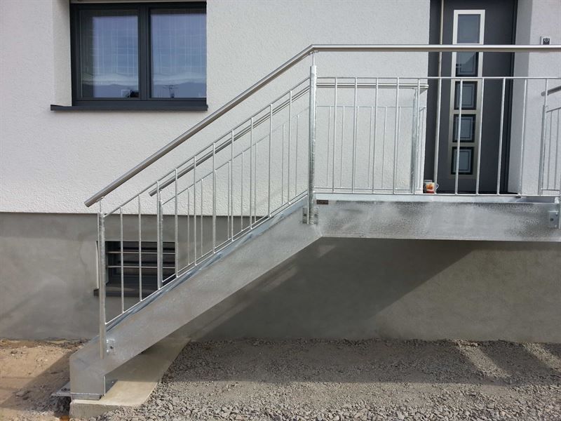 Eine Metalltreppe, die zu einem Haus mit einem Edelstahlgeländer führt