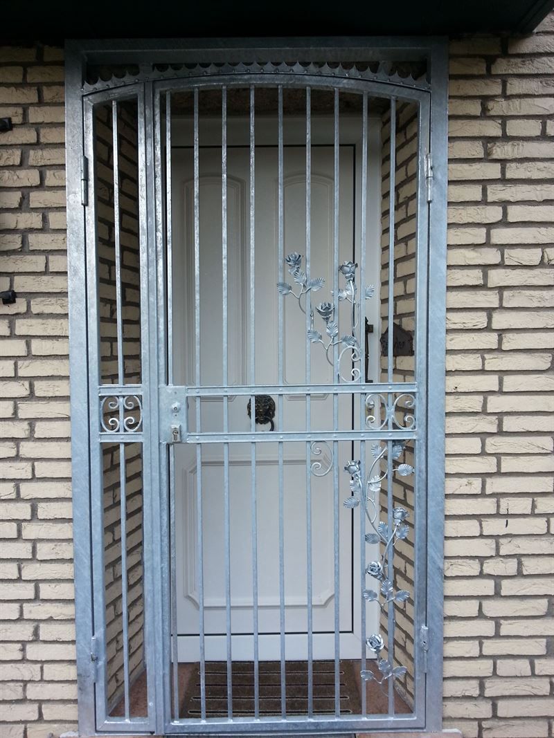 Eine weiße Tür mit einem Metalltor davor