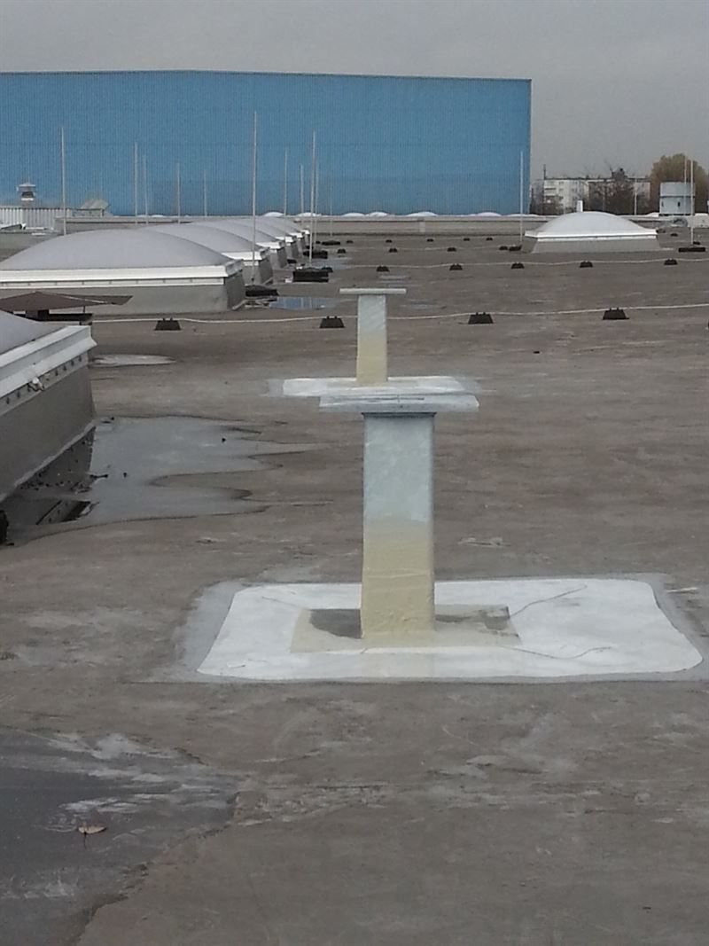 Ein Betondach mit einem blauen Gebäude im Hintergrund.