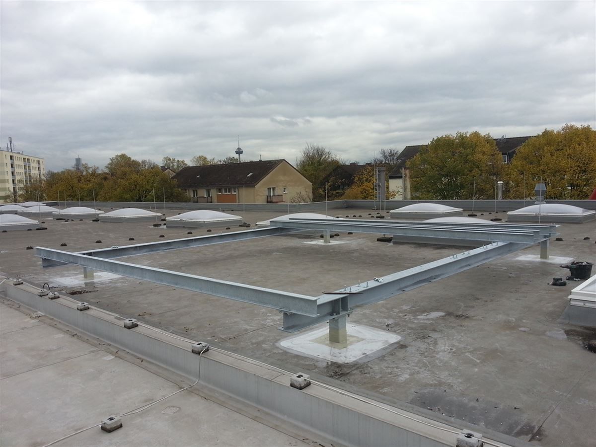 Auf einem Betondach sitzt ein Metallrahmen.