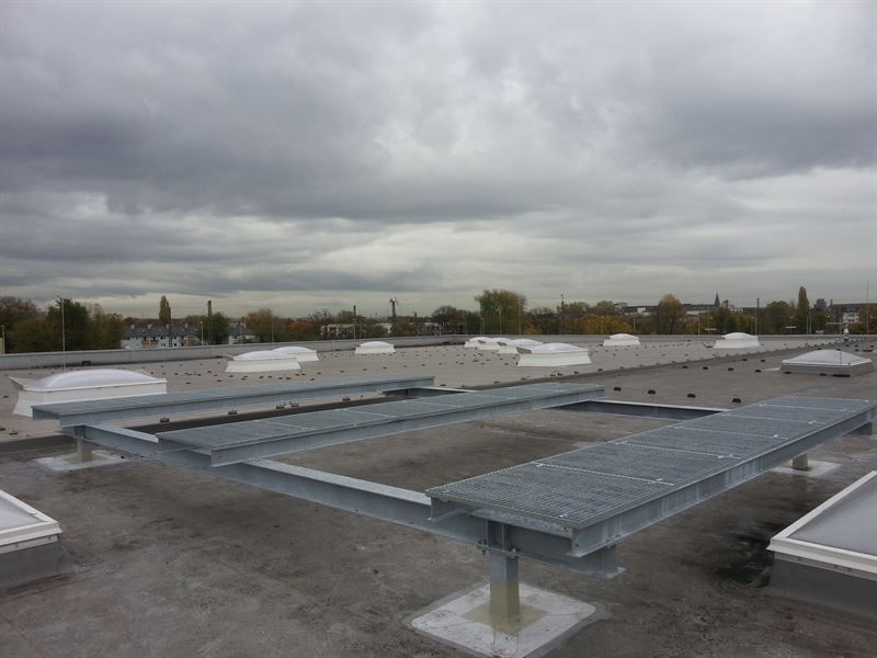 Eine Metallplattform auf einem Dach mit einem bewölkten Himmel im Hintergrund.