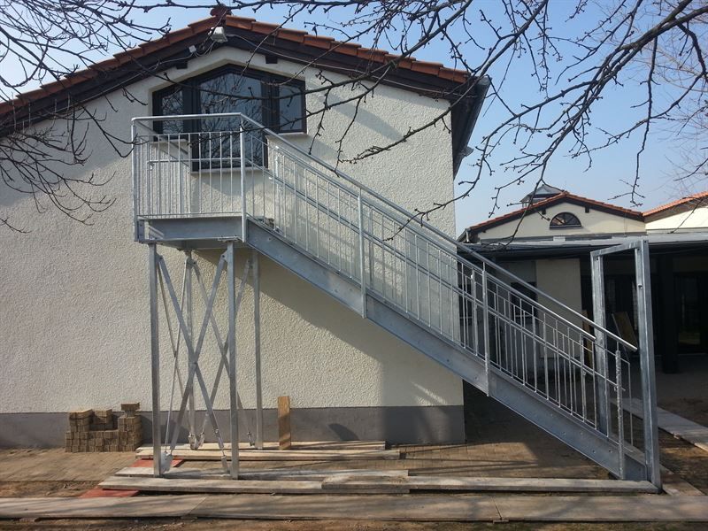 Ein weißes Haus mit einer Metalltreppe, die hinaufführt