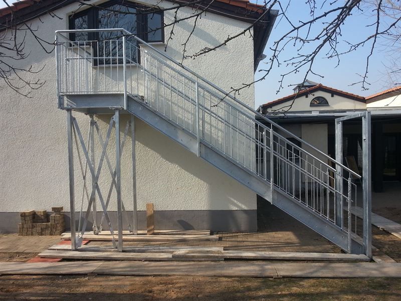 An der Seite eines Hauses wird eine Metalltreppe gebaut.