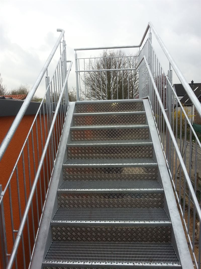 Eine Metalltreppe mit Metallgeländer, die zu einem Gebäude hinaufführt.