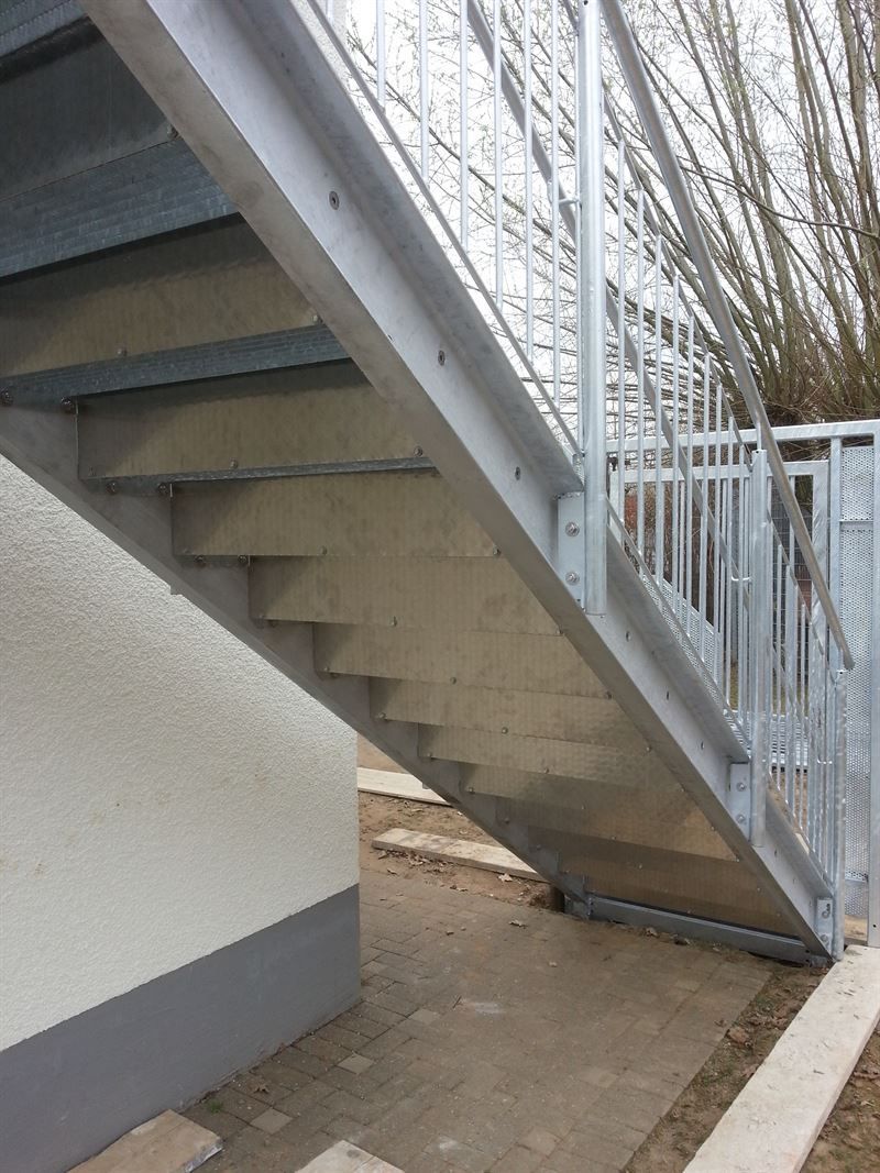 Eine Treppe, die zu einem Gebäude mit einem Metallgeländer hinaufführt.