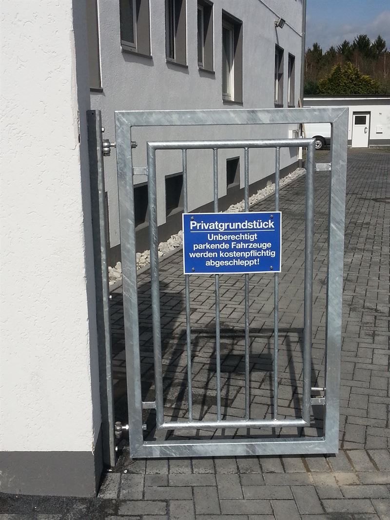 Ein Metalltor mit einem blauen Schild darauf