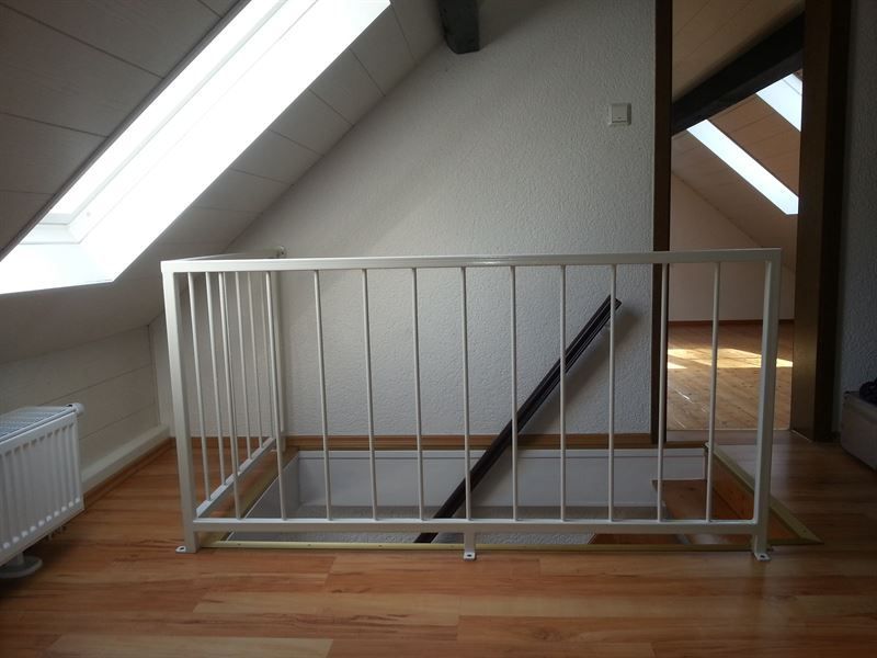 Eine Treppe in einem Dachgeschoss mit einem Metallgeländer