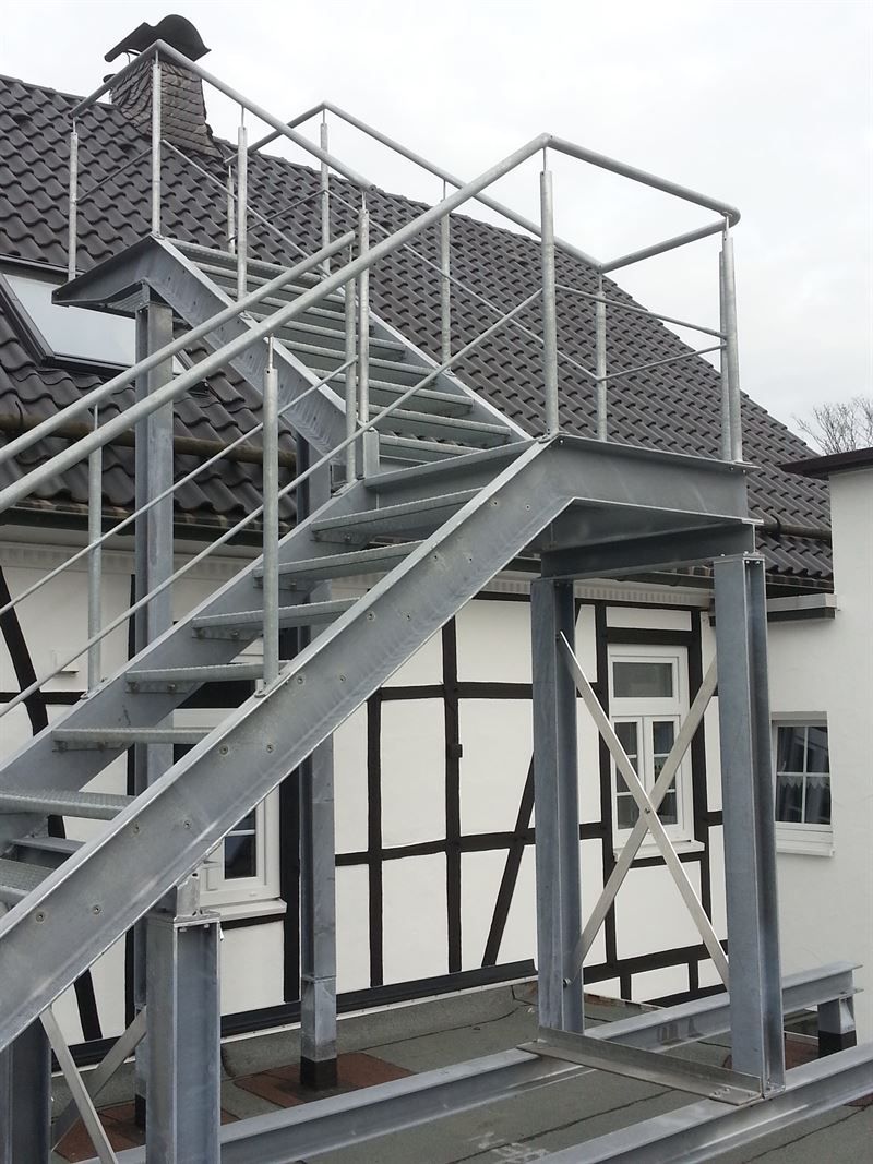 Eine Metalltreppe, die zu einem weißen Gebäude führt