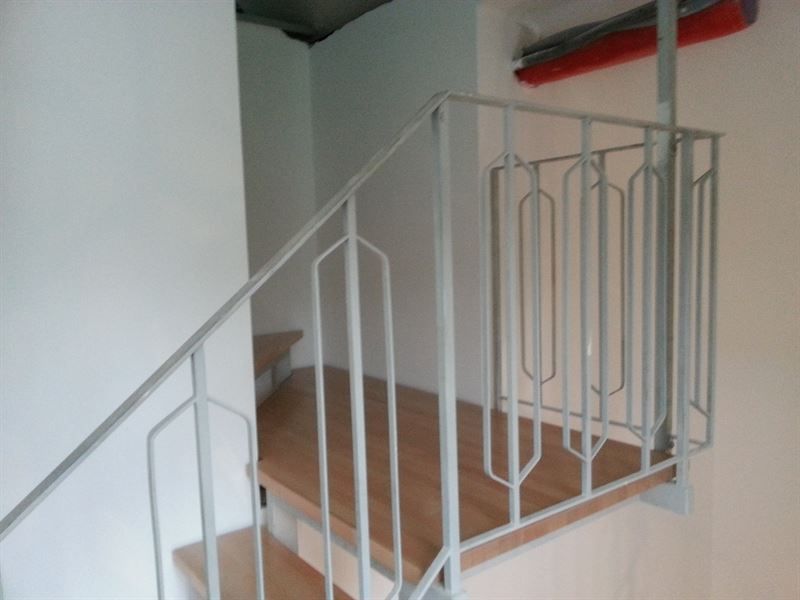 Eine Treppe mit weißem Geländer und Holzstufen