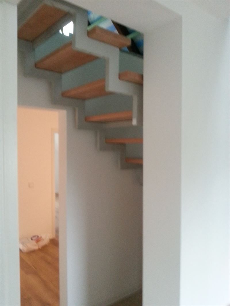 Eine Treppe mit Holzstufen in einem weißen Raum