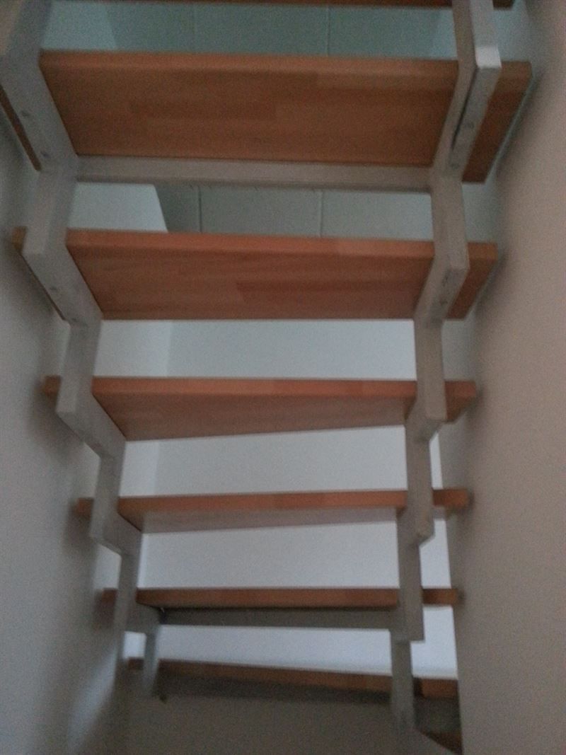 Eine Treppe mit Holzstufen und weißem Geländer