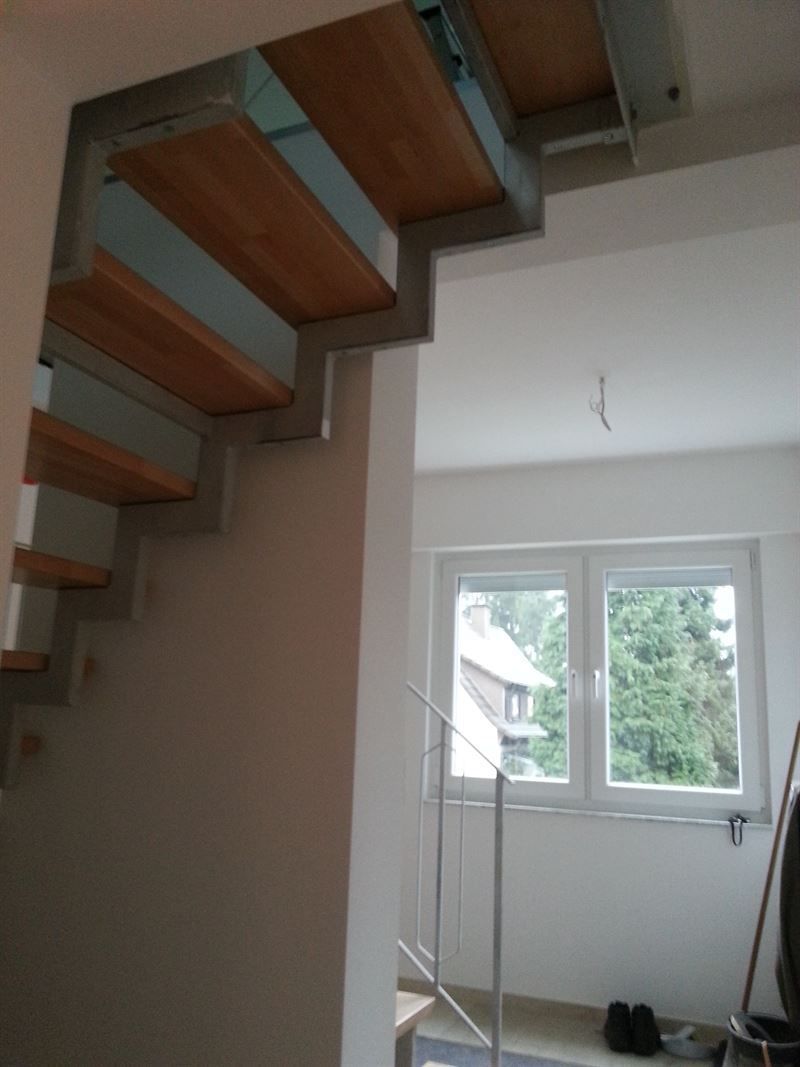 Eine Holztreppe in einem Raum mit einem Fenster