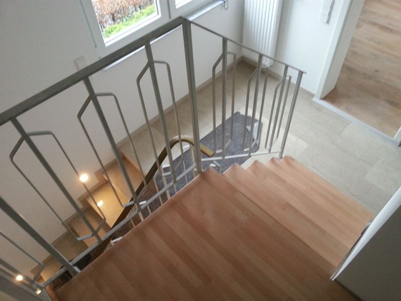 Eine Wendeltreppe mit Metallgeländer und Holzstufen