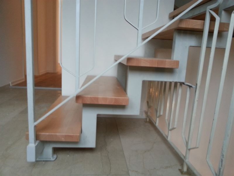 Eine Treppe mit Holzstufen und einem weißen Geländer