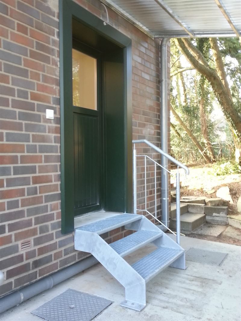 Ein Backsteingebäude mit Treppen, die zu einer Tür führen