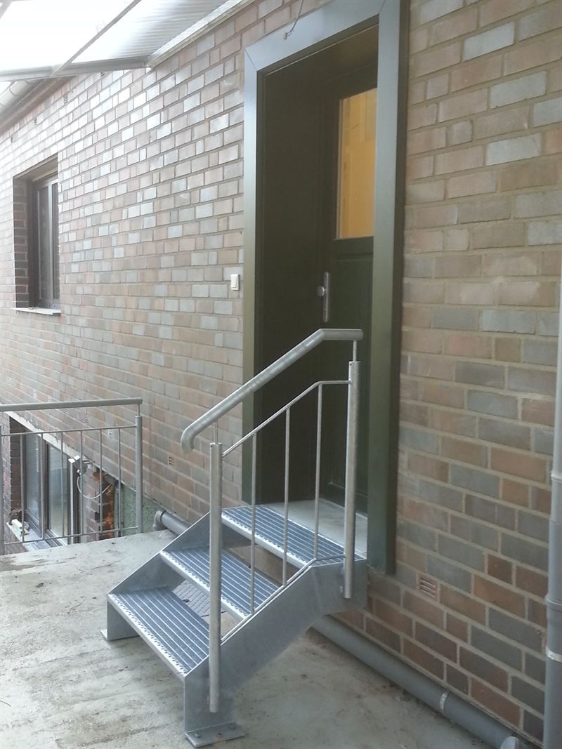 Ein Backsteingebäude mit Treppen, die zu einer Tür führen