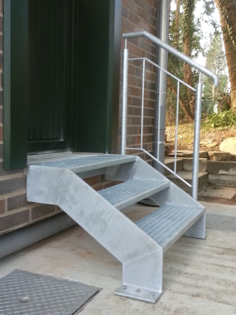 Eine Reihe von Metalltreppen mit einem Geländer an der Seite eines Gebäudes