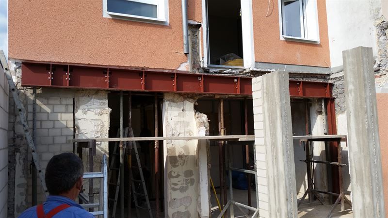 Ein Mann steht vor einem im Bau befindlichen Gebäude.